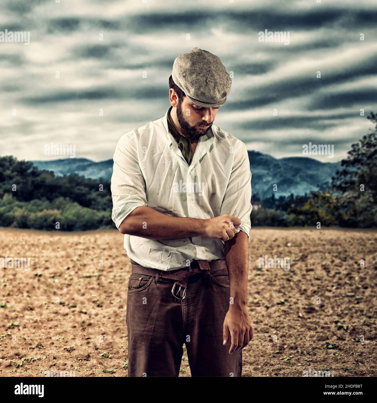 Baskenmütze, Rolling up Sleeves, Farmarbeiter, Baskenmütze, Arbeiter, Mitarbeiter Stockfoto