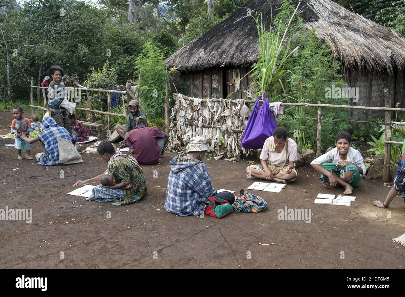 Papua-Neuguinea; Östliches Hochland; Goroka; Papua ruhen und spielen auf dem Platz vor der Hütte. Papuas ruhen and spielen auf dem Platz vor der Hütte Stockfoto