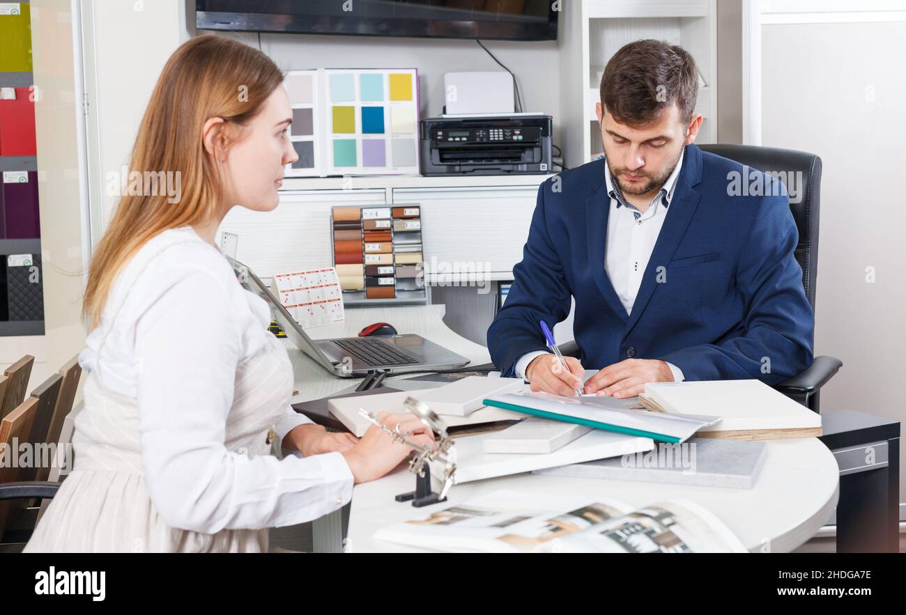 Frau, die Möbel mit dem Verkäufer plant Stockfoto