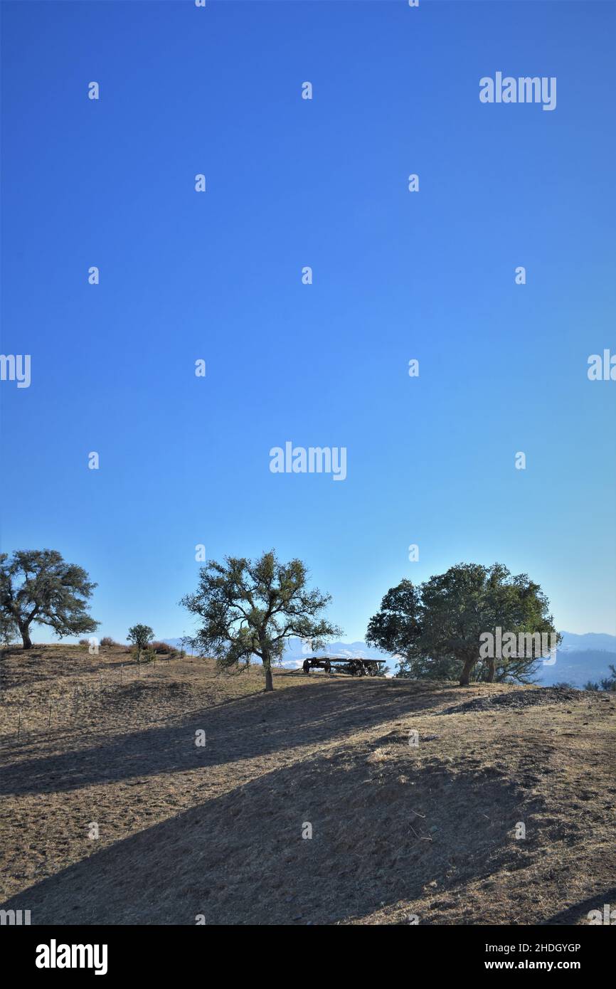 Alte auseinander fallen antiken Wagen auf Kamm in den einsamen Küstenbergen von Kalifornien unter den Eichen mit Himmel für Text und Kopie Stockfoto