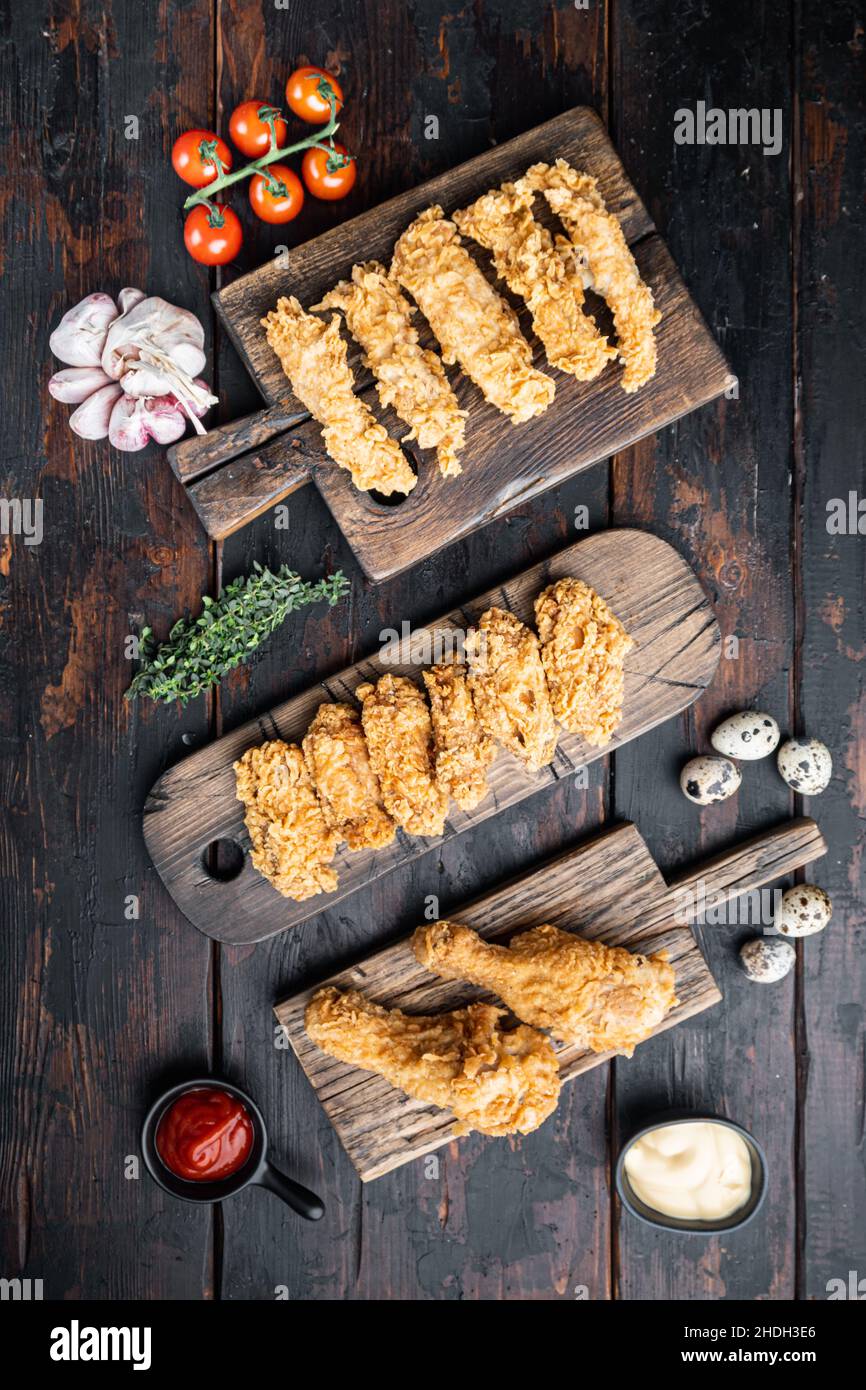 Hausgemachte knusprig gebratene Hühnerteile auf alten dunklen Holztisch, flach legen. Stockfoto