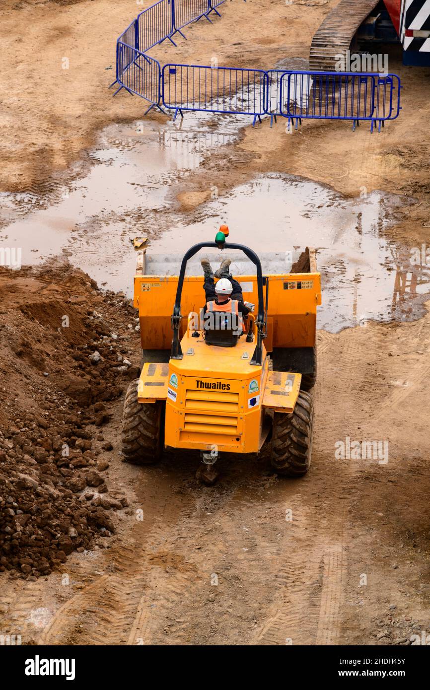 Baustellenarbeiter und Fahrzeug in Arbeitspause (Füße hoch auf skip, wobei Ruhe in gelben Dumper LKW) - York City Centre, North Yorkshire, England Großbritannien Stockfoto