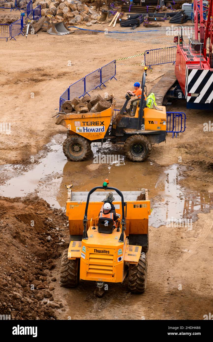 Bauarbeiter und gelbe Dumper Fahrzeuge (1 arbeiten & einer mit einer Pause von der Arbeit) - York City Center Baustelle, North Yorkshire England Großbritannien. Stockfoto