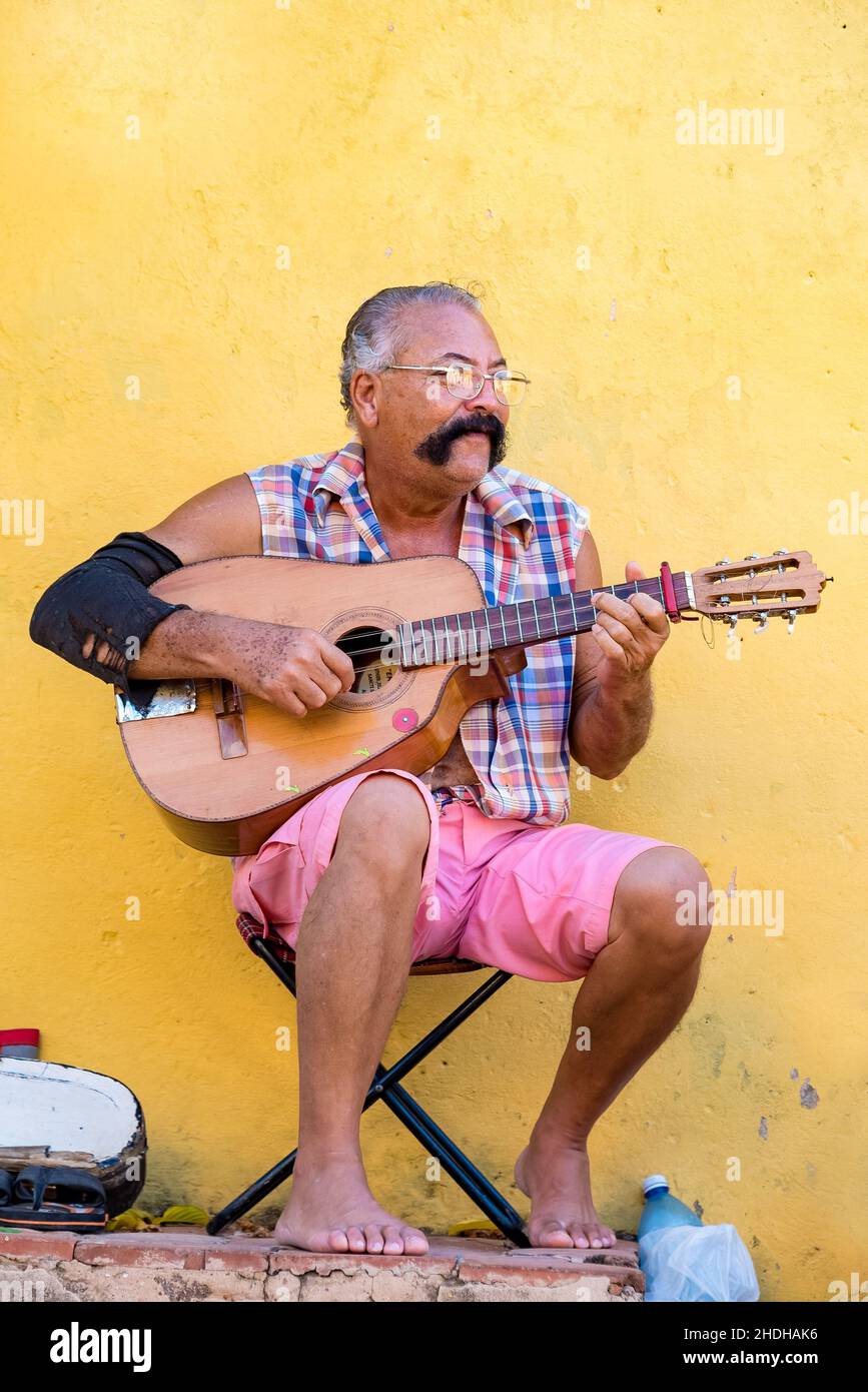 Porträt eines älteren kubanischen Mannes, der auf der Straße in Trinidad Gitarre spielt. Er hat einen großen Schnurrbart. Januar 6, 2022 Stockfoto