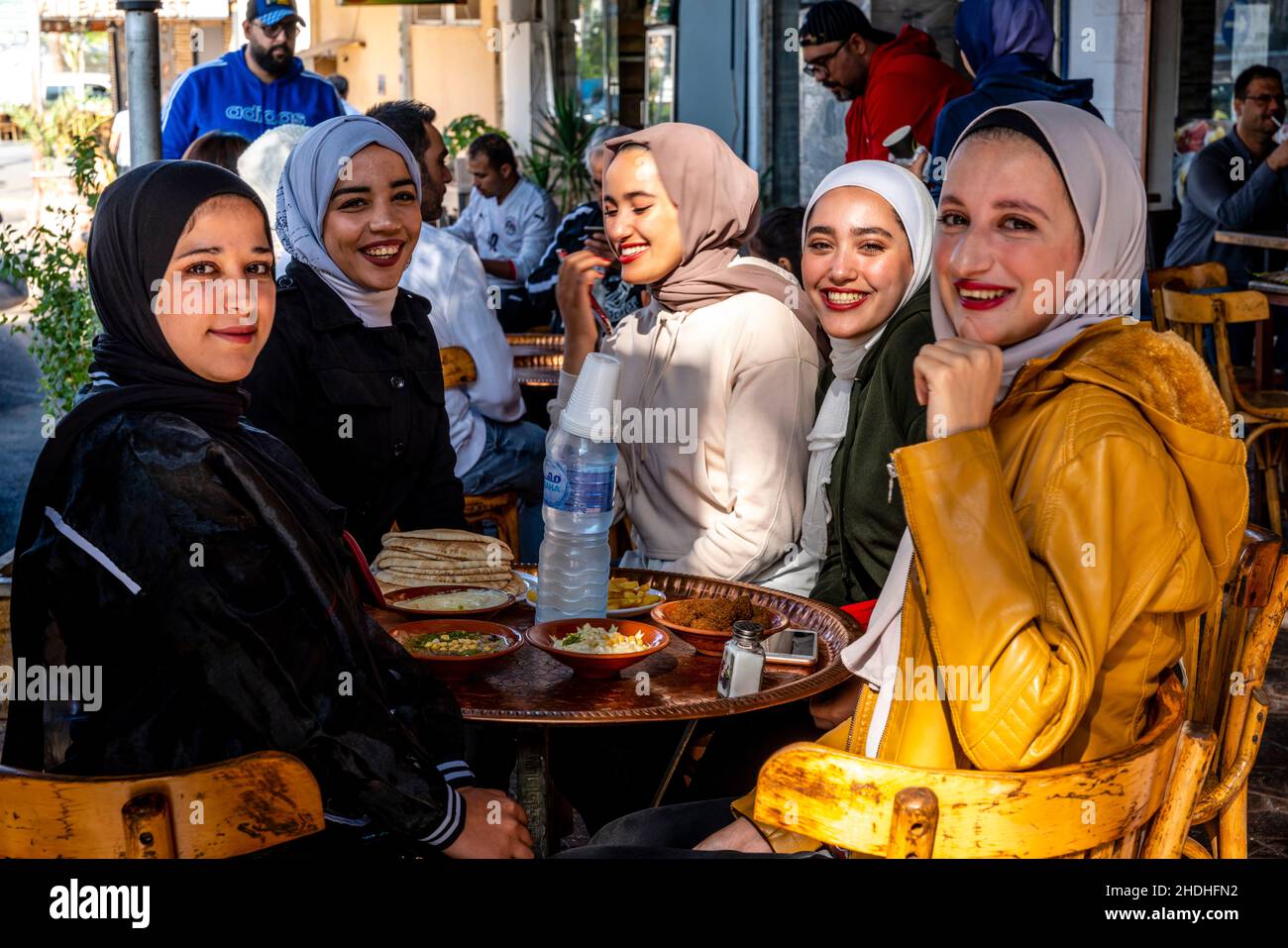Eine Gruppe junger jordanischer Frauen genießt das Frühstück vor einem Café in Aqaba, Governorate Aqaba, Jordanien. Stockfoto