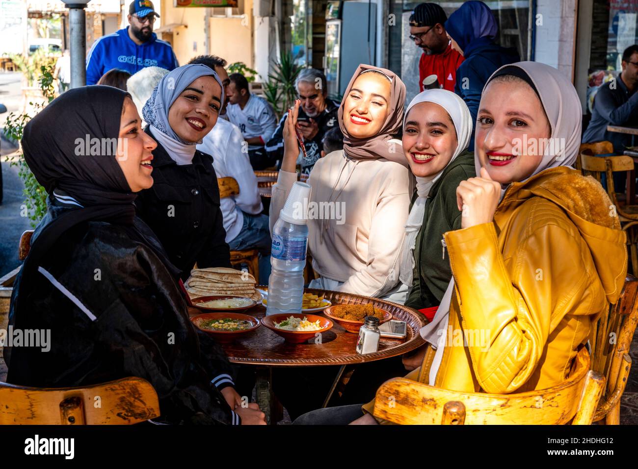 Eine Gruppe junger jordanischer Frauen genießt das Frühstück vor einem Café in Aqaba, Governorate Aqaba, Jordanien. Stockfoto