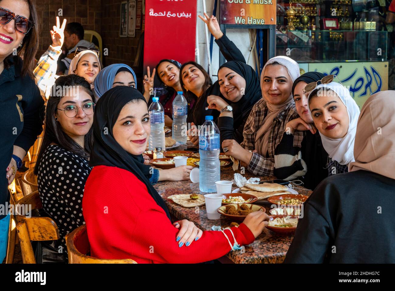 Eine Gruppe junger jordanischer Frauen genießt das Frühstück vor einem Café in Aqaba, Governorate Aqaba, Jordanien. Stockfoto