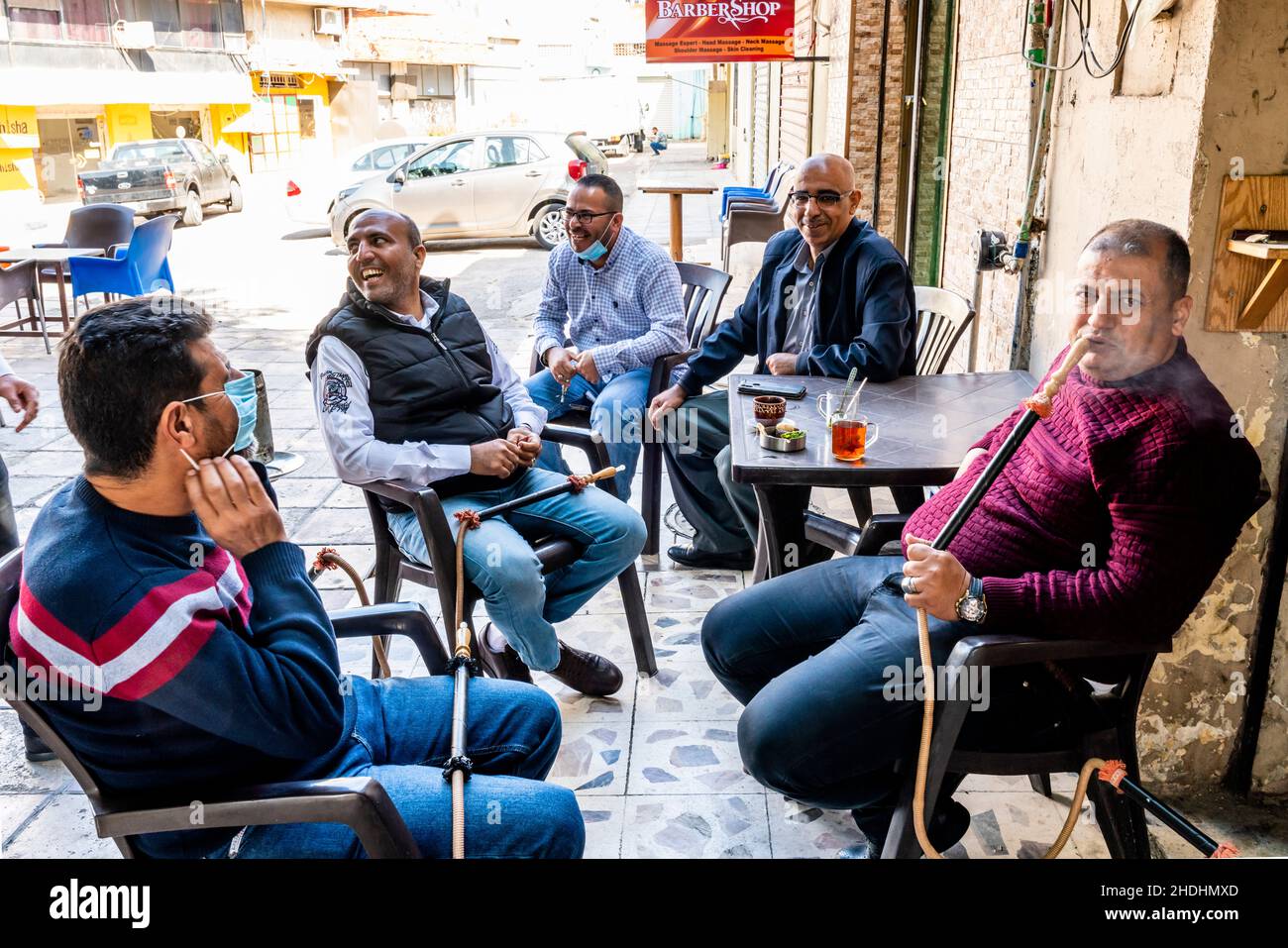 Eine Gruppe von Männern sitzt um Einen Tisch und plaudert und rauchen Shisha-Pfeifen, Aqaba, das gouvernement Aqaba, Jordanien. Stockfoto