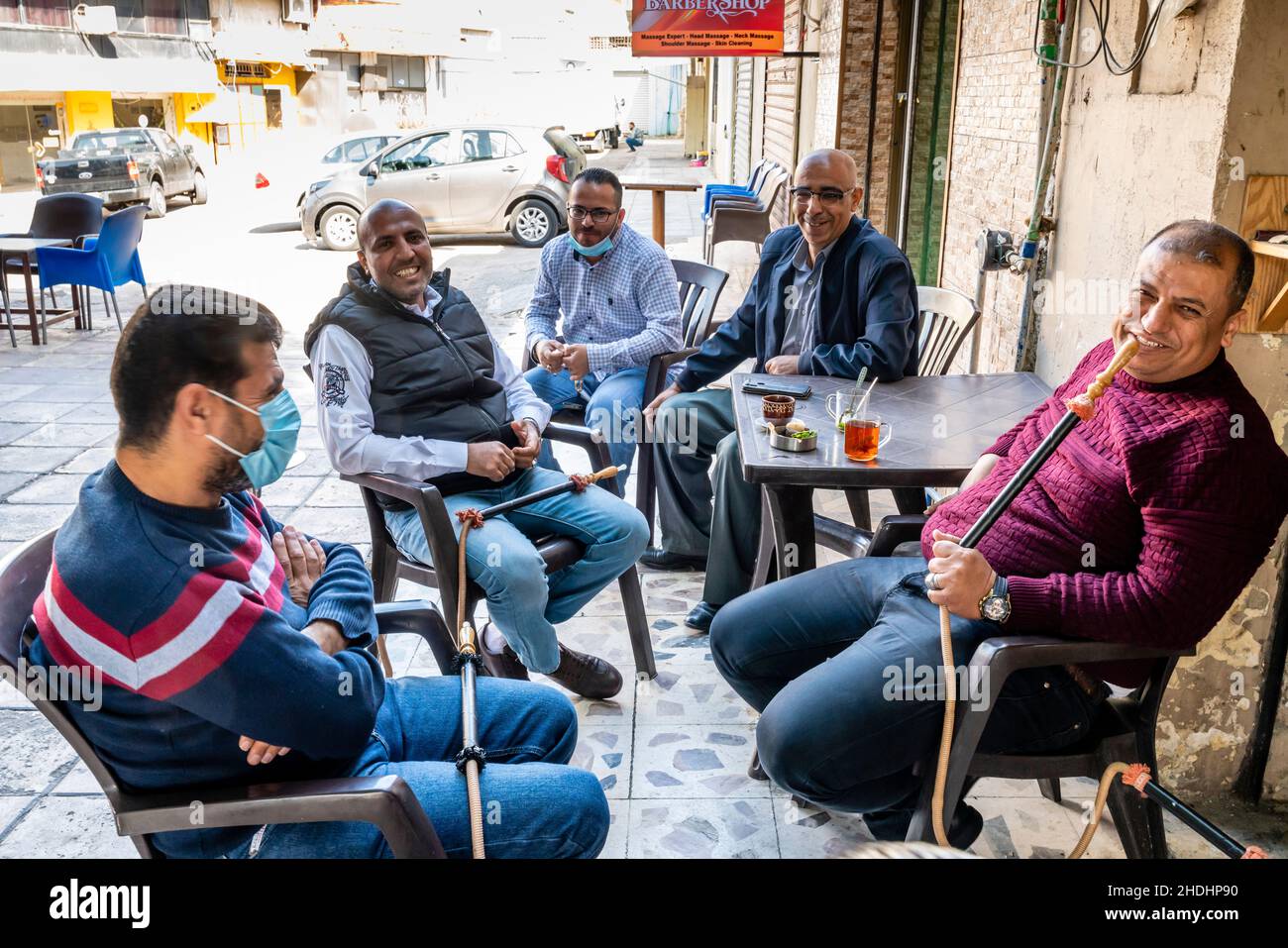 Eine Gruppe von Männern sitzt um Einen Tisch und plaudert und rauchen Shisha-Pfeifen, Aqaba, das gouvernement Aqaba, Jordanien. Stockfoto