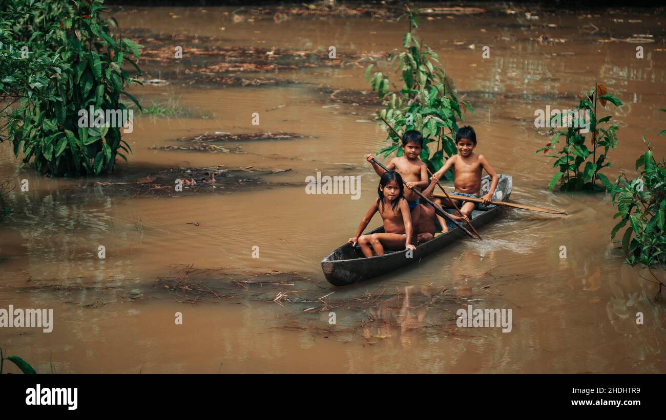 Indigene Kinder rudern den Amazonas entlang, Ecuador Stockfoto