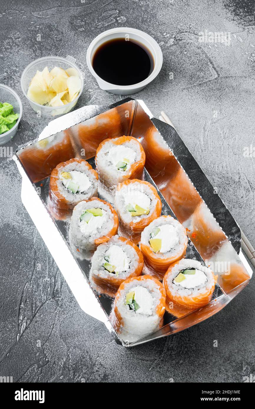 Verschiedene Sushi- und Rolls-Sets, Lachs und Thunfisch im Lieferlebensmittelkonzept auf grauem Steinhintergrund Stockfoto