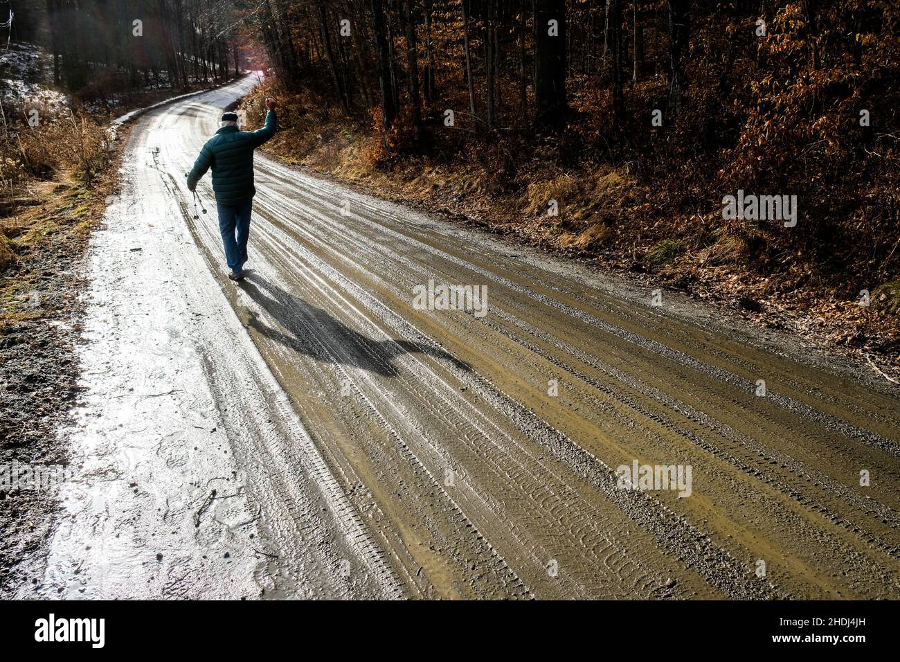 Ein einsamer älterer Mann geht auf einer ländlichen Schotterstraße in East Montpelier, VT, New England, USA. Stockfoto