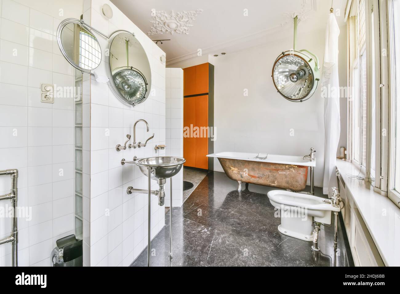 Komfortables, großes Badezimmer mit einer Badewanne mit Clawfoot-Füßen und grauem Boden Stockfoto