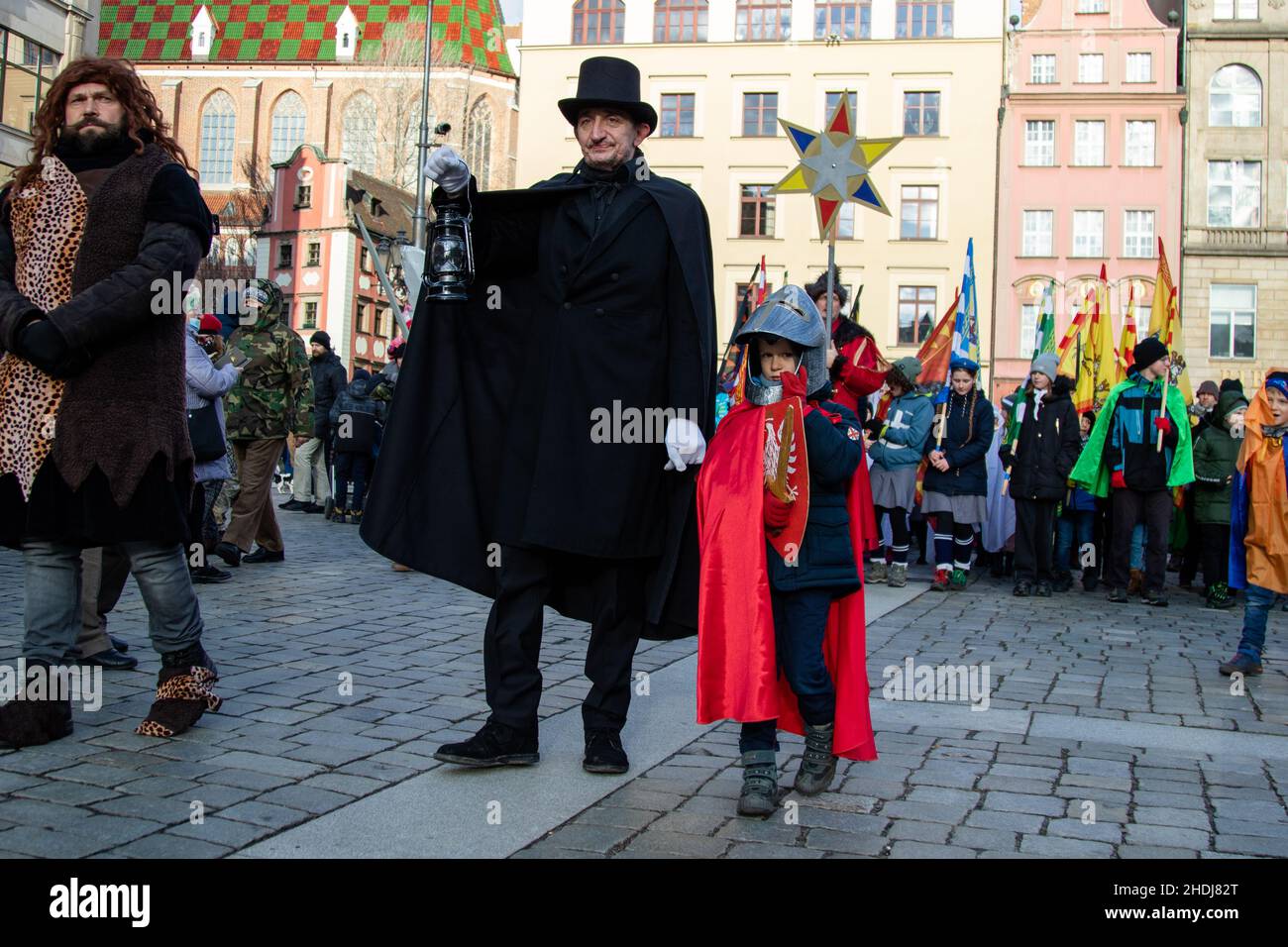 Breslau, Polen. 06th Januar 2022. Der Wroclaw lamplighter in einer schwarzen Robe mit einem Jungen, der als polnischer Ritter gekleidet ist, führt die Epiphanie-Prozession, die auch als Prozession der drei Könige bekannt ist, entlang der Straßen des Nowy Targ Platzes. Kredit: SOPA Images Limited/Alamy Live Nachrichten Stockfoto