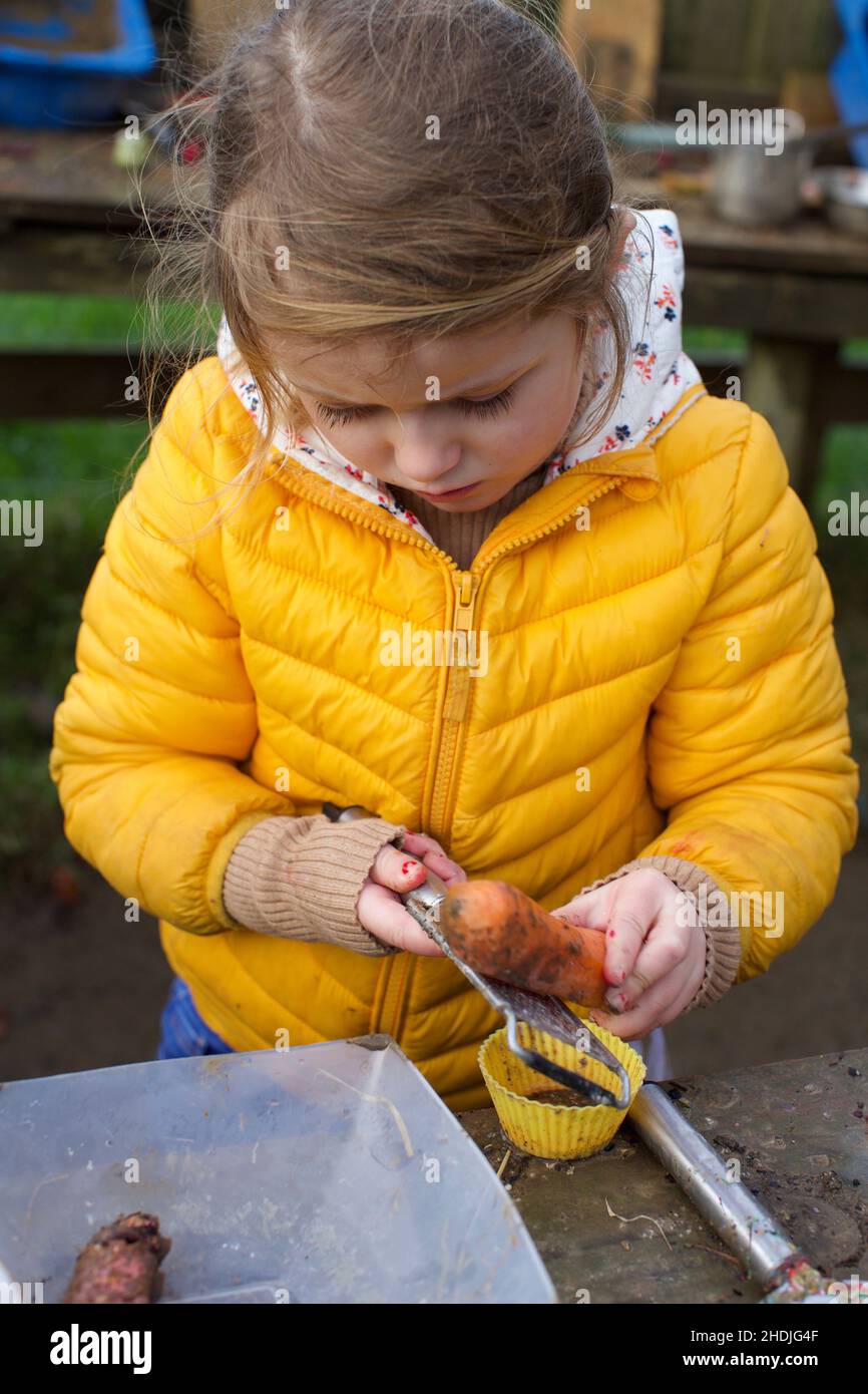 Ein 5-jähriges Kind spielt im Freien in einer Schlammküche, Großbritannien Stockfoto