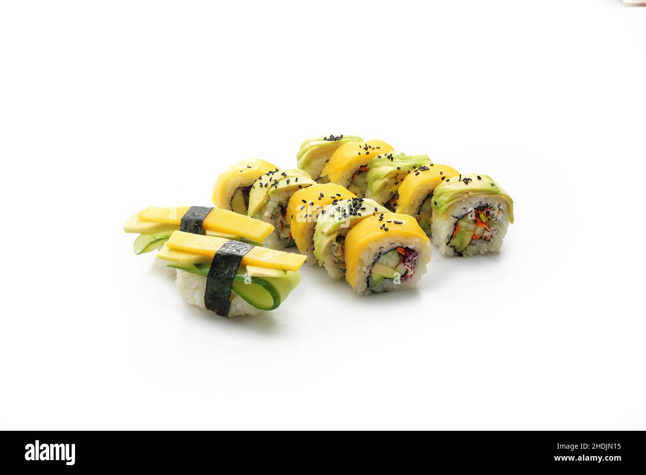Sushi mit gelber Rübe und Avocado. Sushi rollt auf weißem Hintergrund. Traditionelles japanisches Sushi Stockfoto