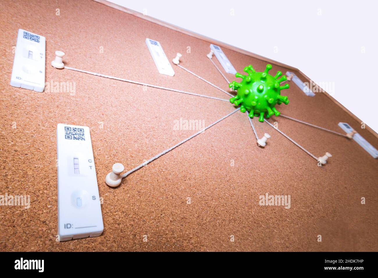 Eine Kork Evidence Board mit mehreren Saiten aus der Mitte Punkt gehen, um Pins um das Brett. Lösung des komplizierten Falles des Coronavirus. Stockfoto
