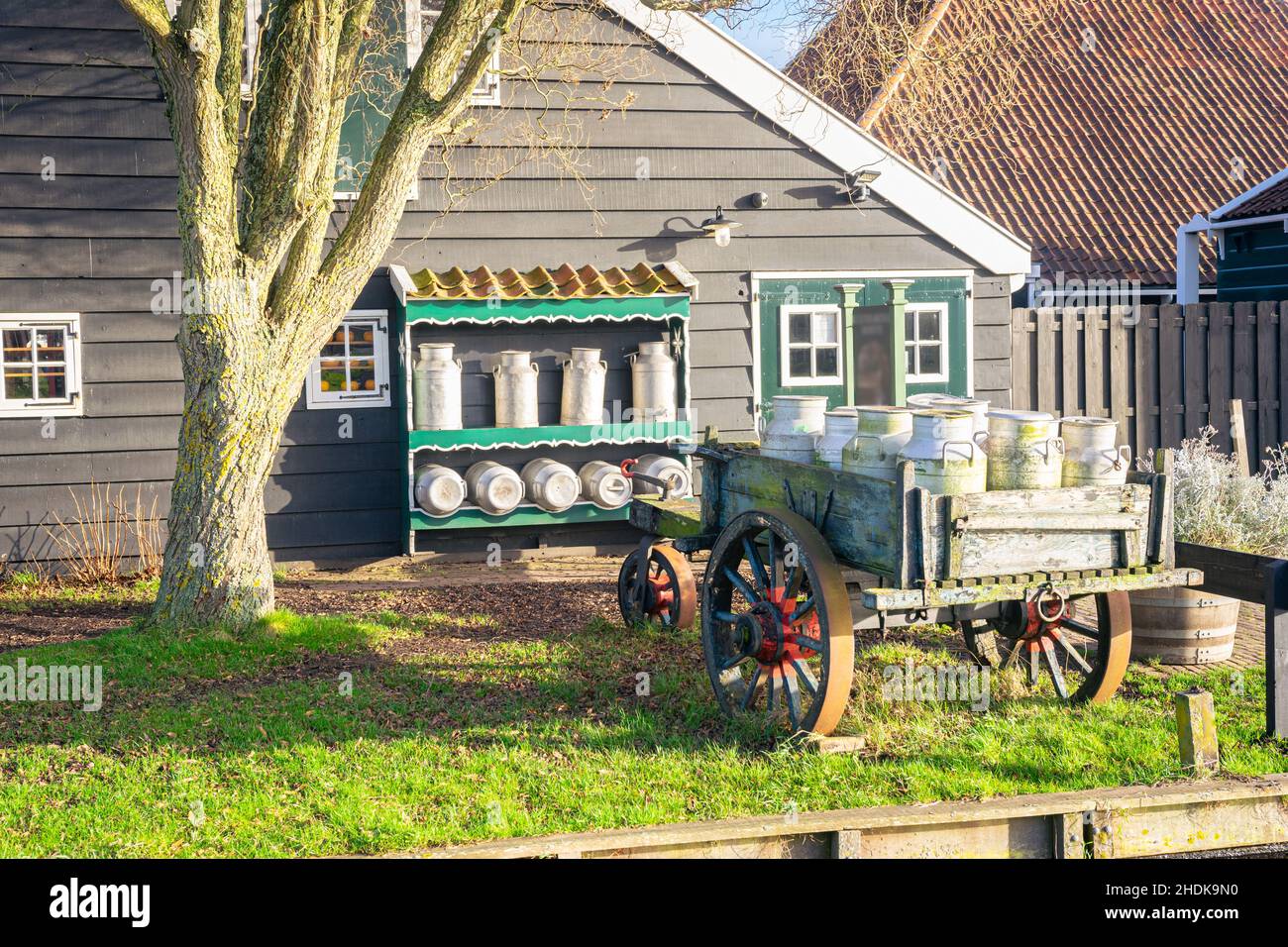 Alte holländische Szene mit einem Wagen mit Milchdosen auf einem Bauernhof Stockfoto