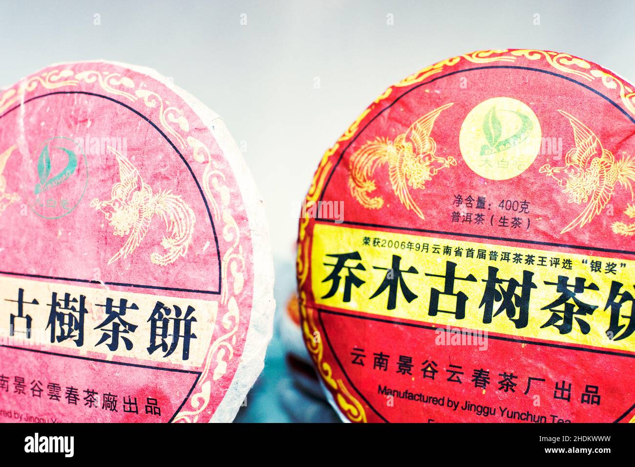 Puehr Teekuchen in leuchtend roten und gelben Papierverpackungen, zum Verkauf in einem Teeladen in Hongkong. Stockfoto