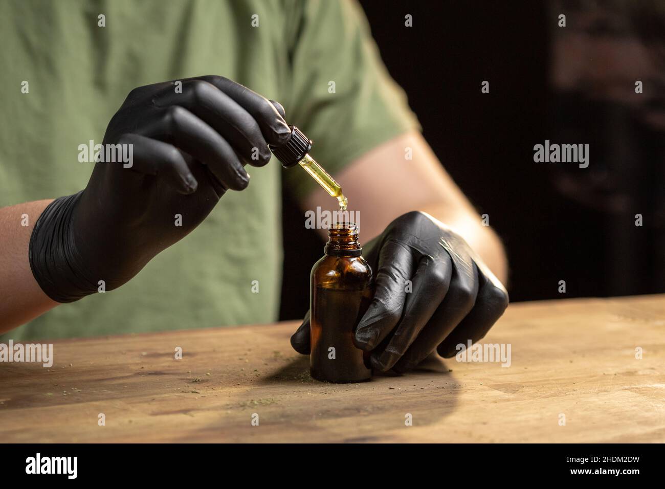 Hände tropfende CBD-Öltropfen in Glasflasche mit einer Pipette. Stockfoto