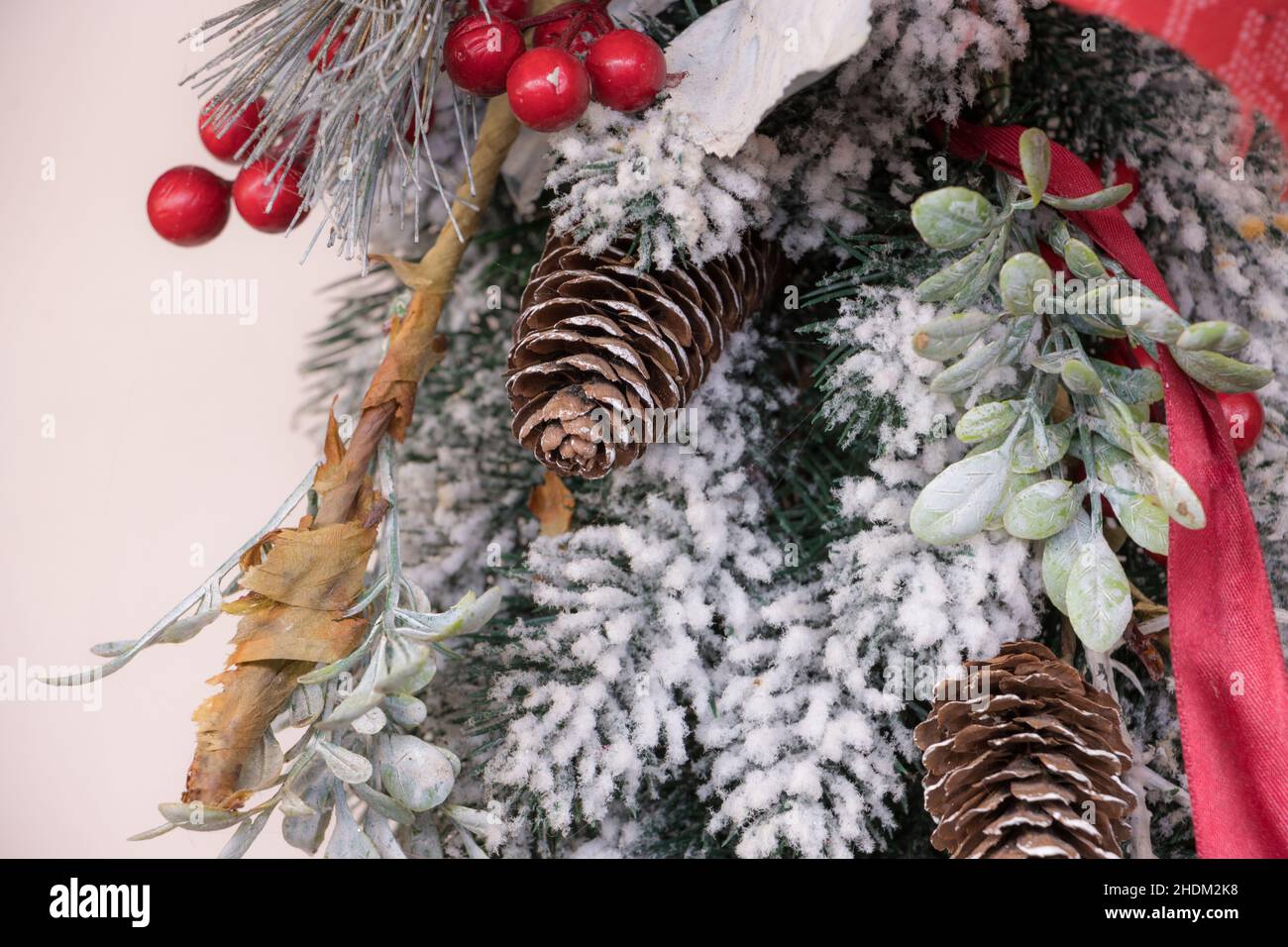 Weihnachtliche Dekoration mit Schnee, Evergreens, Kegelbällen und Feiertagsmotiven. Goldenes und rotes Band. Frohes neues Jahr und frohe Weihnachten. Stockfoto