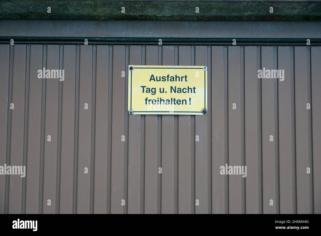 Türschild, um den Ausgang Tag und Nacht in deutscher Sprache frei zu halten Stockfoto