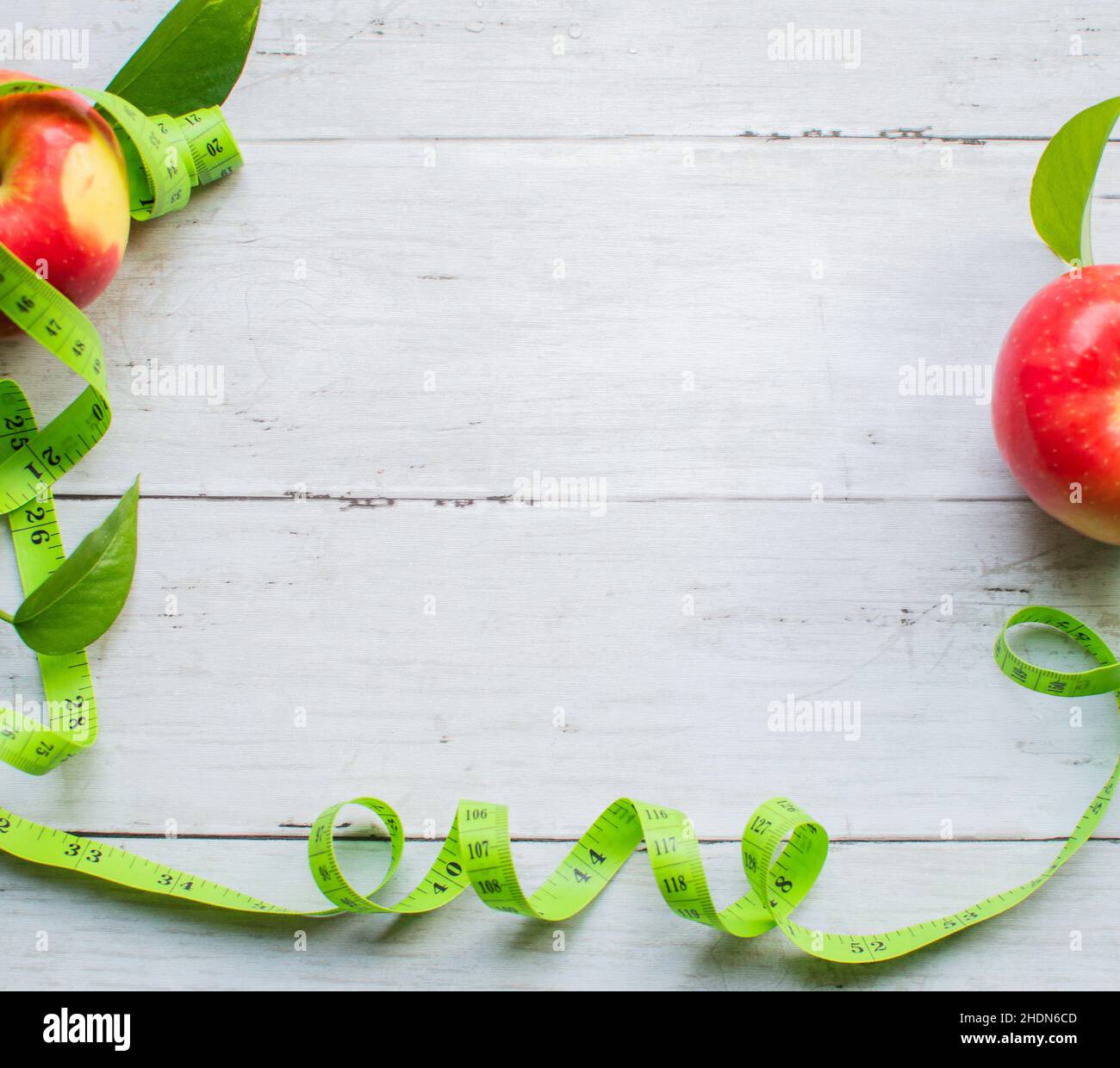 Gewichtsverlust Konzept, Apfel und Maßband auf der leichten Holzoberfläche Stockfoto