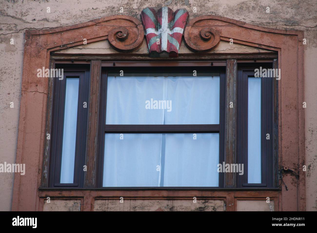 Nahaufnahme eines Gebäudefensters mit der baskischen Flagge oben Stockfoto