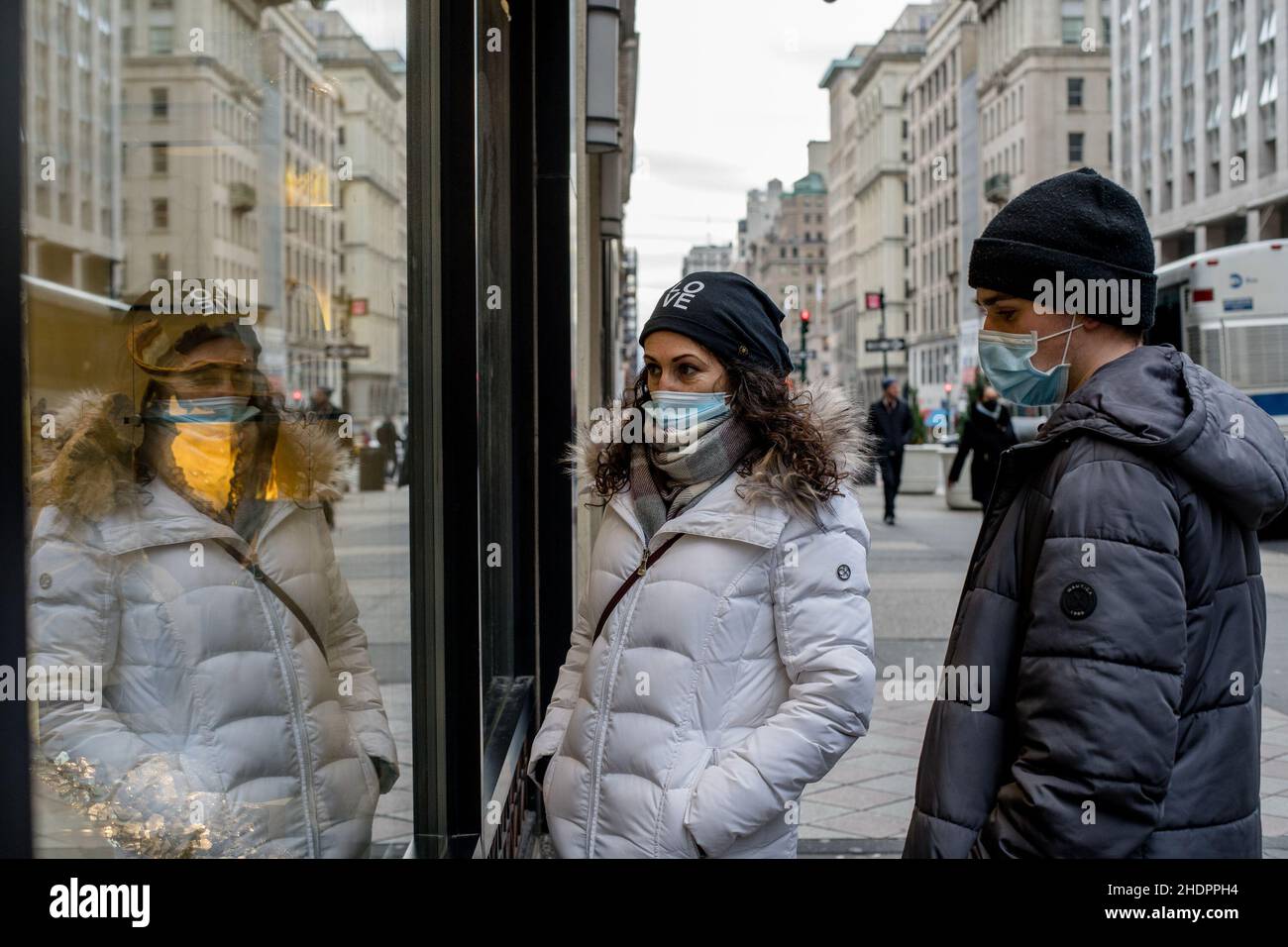 New York, Usa. 27th Dez 2021. Eine Frau, die eine Gesichtsmaske trägt, schaut auf ihre Reflexion auf einem Fenster während der COVID-19 pandemischen omicron-Welle. (Foto: Shawn Goldberg/SOPA Images/Sipa USA) Quelle: SIPA USA/Alamy Live News Stockfoto