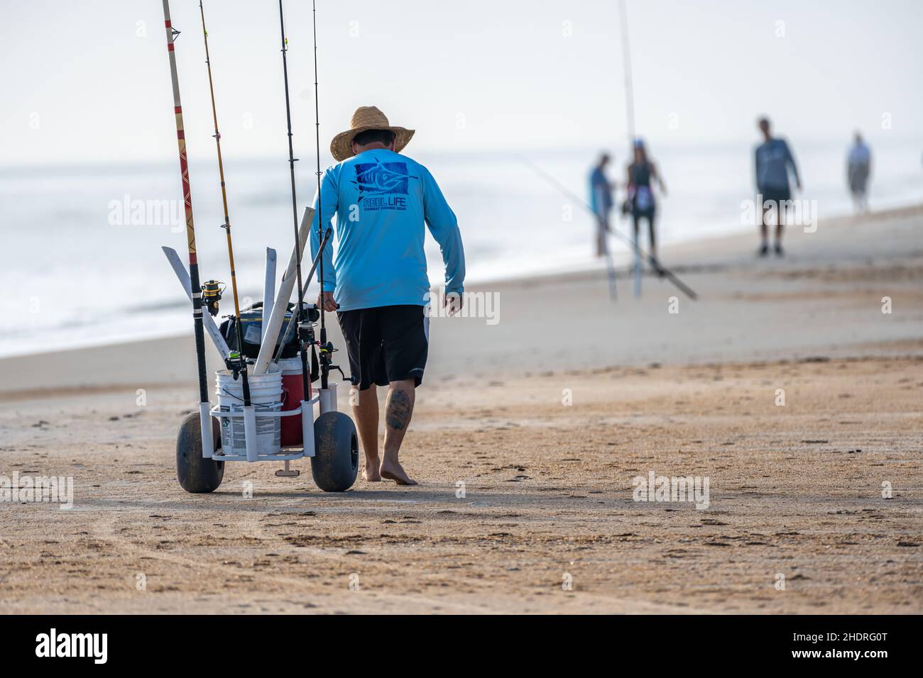 Strandfischer zieht Angelausrüstung entlang der Küste am Mickler Beach in Ponte Vedra Beach, Florida. (USA) Stockfoto