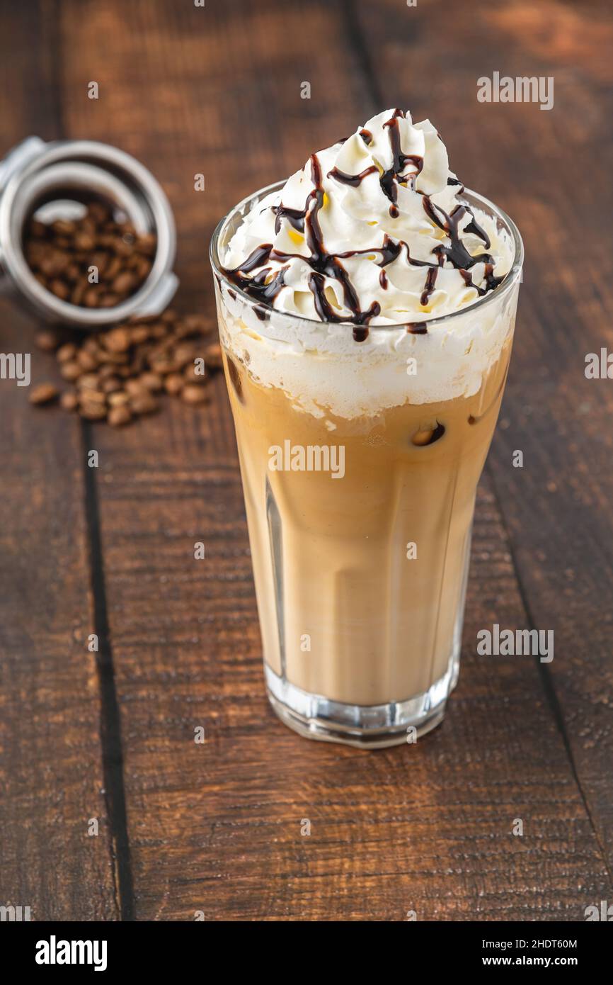 Eistkaffee mit Schlagsahne in Glastasse auf Holztisch Stockfoto