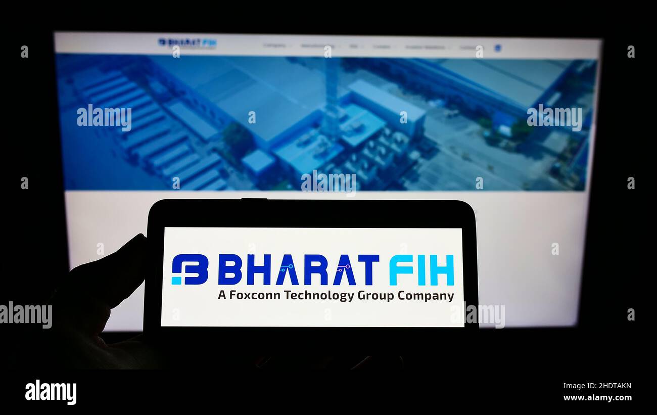 Person, die Smartphone mit dem Logo des indischen Elektronikunternehmens Bharat FIH Private Ltd auf dem Bildschirm vor der Website hält. Konzentrieren Sie sich auf die Telefonanzeige. Stockfoto