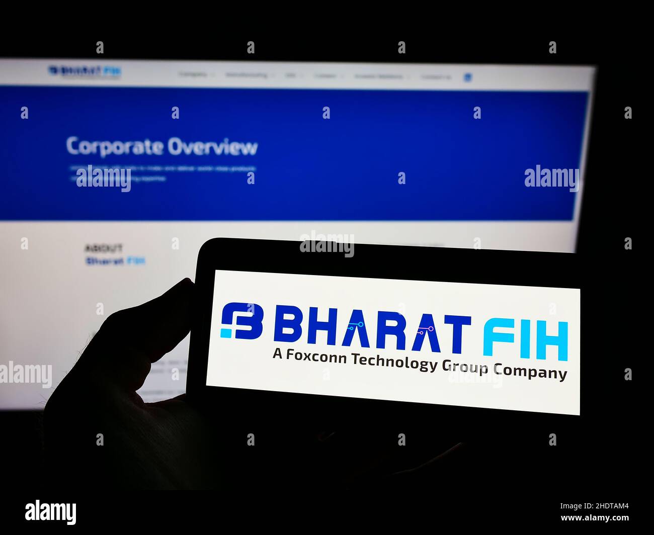 Person, die ein Mobiltelefon mit dem Logo des indischen Elektronikunternehmens Bharat FIH Private Ltd auf dem Bildschirm vor der Webseite hält. Konzentrieren Sie sich auf die Telefonanzeige. Stockfoto
