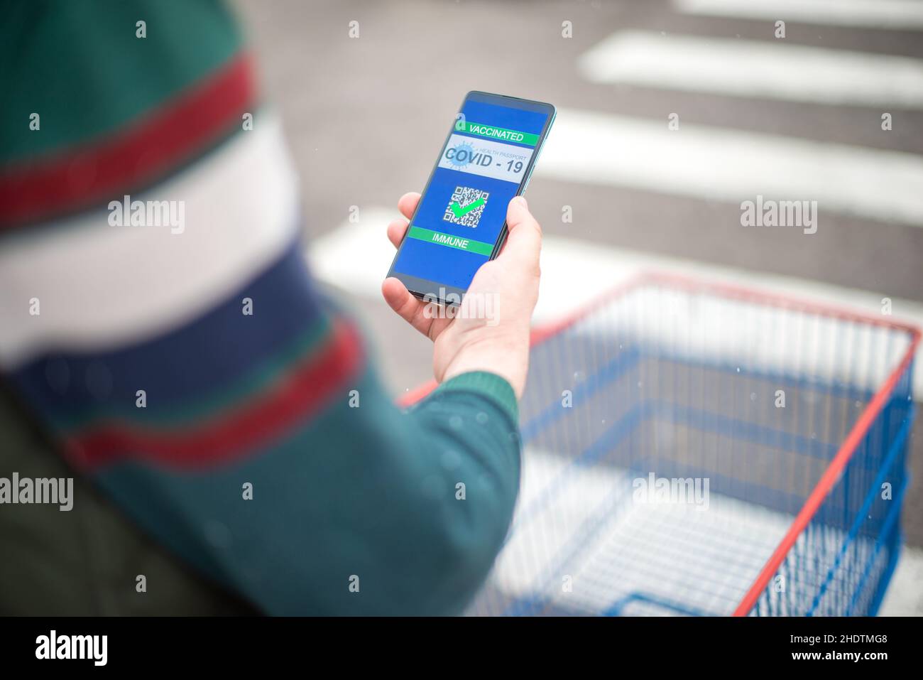Mann mit Covid Zertifikat auf dem Smartphone, die ihm erlauben, Waren zu kaufen Stockfoto