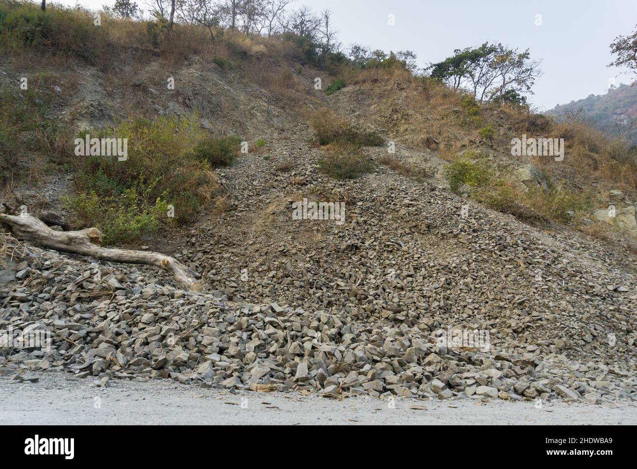 Erdrutsch auf einer leeren Asphaltstraße im ländlichen Indien, umgeben von Bergen im unteren Himalaya. Stockfoto