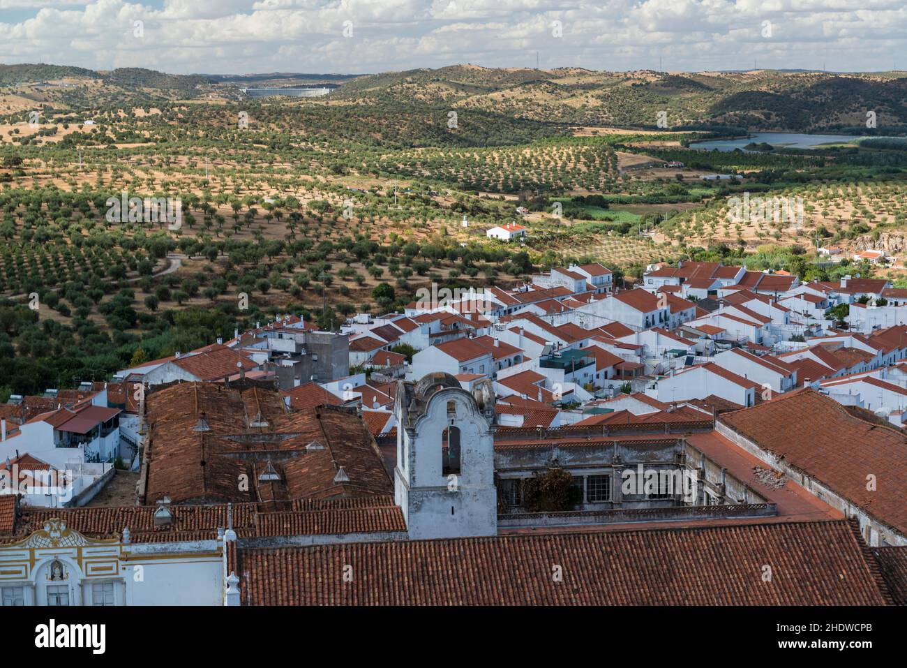 Blick von der Spitze des Turms der Burg von Moura auf dem Convento do Carmo, weiß getünchte Häuser und Landschaft mit Olivenbäumen übersät. Alentejo, Portugal Stockfoto