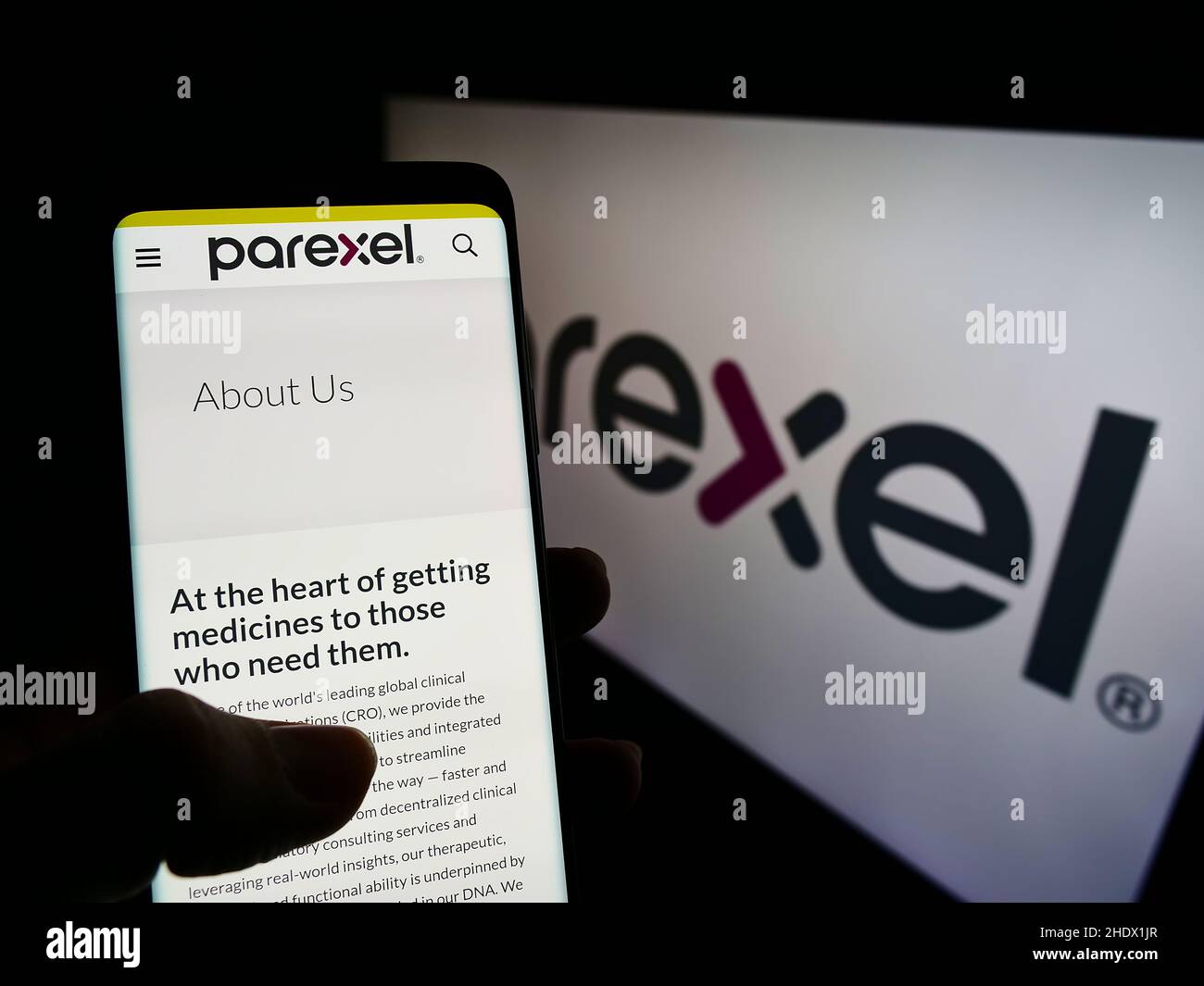 Person, die Mobiltelefon mit Website der Firma Parexel International Corporation auf dem Bildschirm mit Logo hält. Konzentrieren Sie sich auf die Mitte des Telefondisplays. Stockfoto