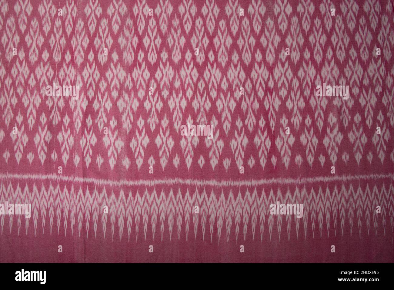 Handgewebter Baumwollstoff in rosa Farbe im Thai-Muster im antiken Stil. Draufsicht für Hintergrund oder Hintergrundbild Stockfoto