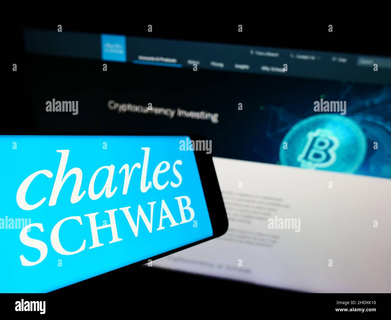 Handy mit Logo des US-Finanzunternehmens The Charles Schwab Corporation auf dem Bildschirm vor der Website. Konzentrieren Sie sich auf die Mitte links des Telefondisplays. Stockfoto