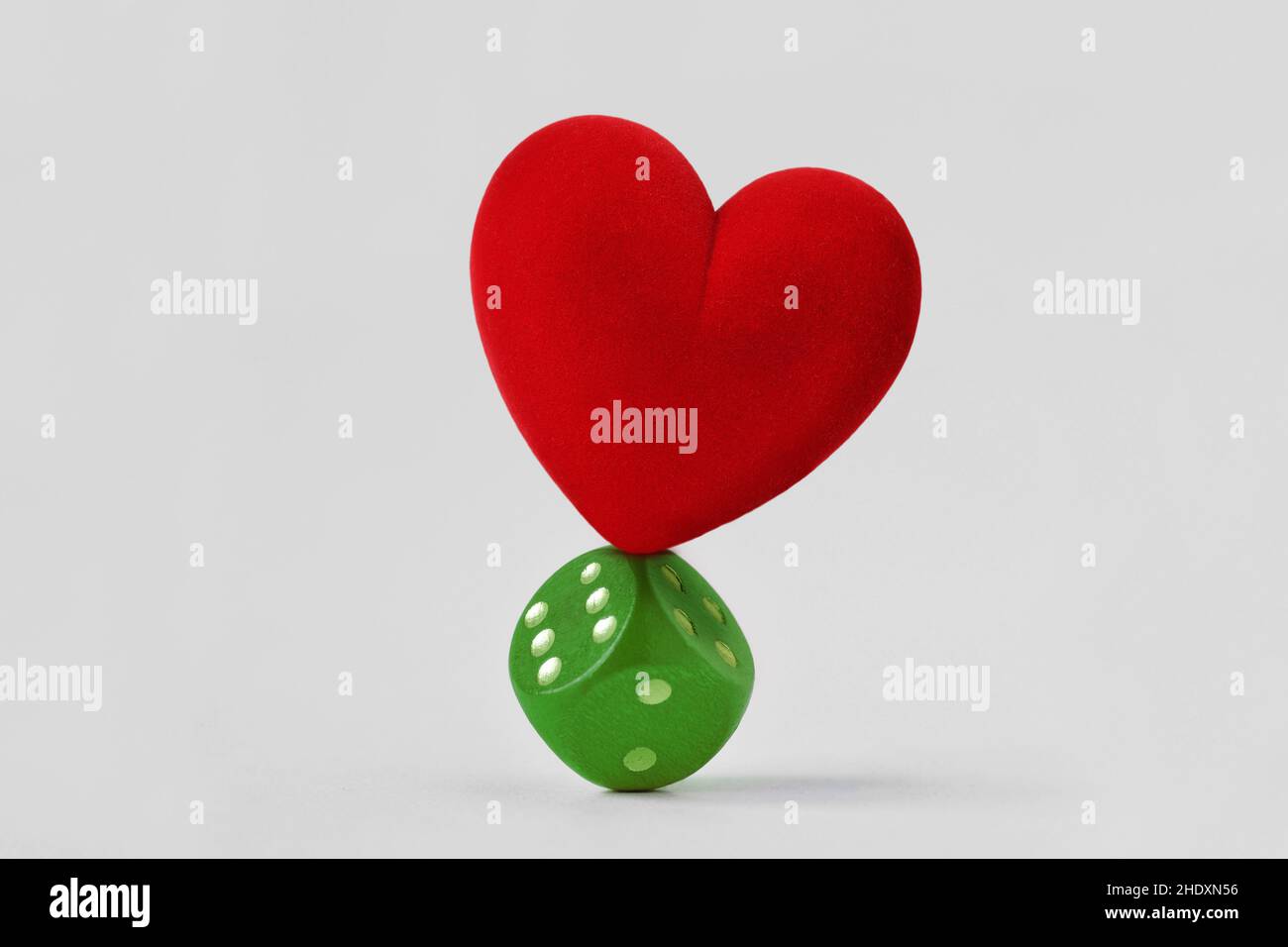 Herz steht auf grünen Würfeln ausgeglichen - Konzept von Liebe und Risiko Stockfoto