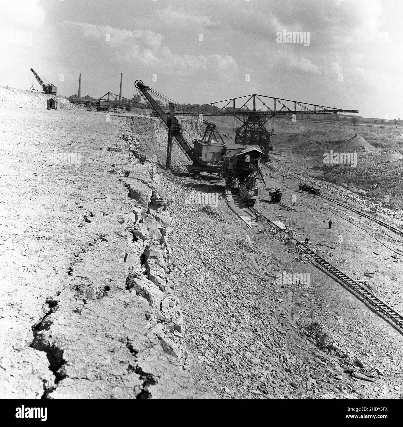 1950s, historisch, Blick über einen riesigen Steinbruch oder Tagebau, wo ein großer mechanischer Bagger aufbricht und die tonhaltige Erde entfernt, die in Brennöfen zu Ziegelsteinen abgefeuert wird, Bedford, England, Großbritannien. In dieser Zeit waren die Ziegelwerke der London Brick Company in Stewartby die größte der Welt. Stockfoto