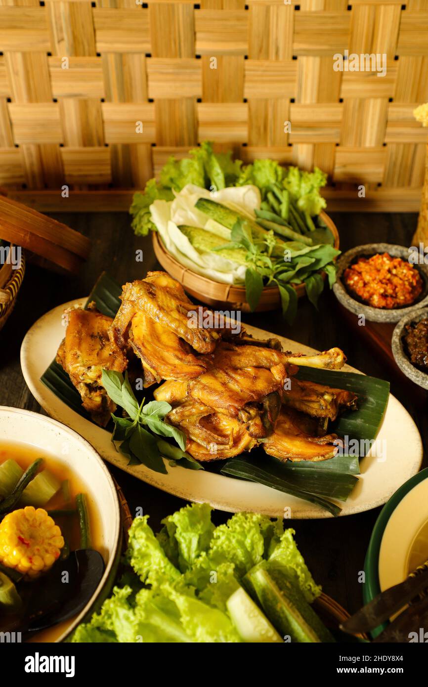 Ayam Goreng. Gebratenes indonesisches Huhn serviert mit Chiliporte, Gemüse und gedämpftem Reis Stockfoto