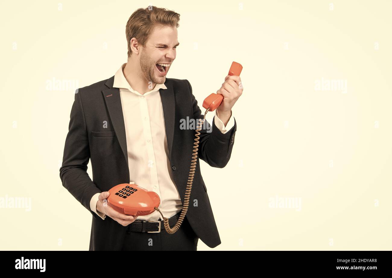 Wütender Mann schreit im Vintage-Telefonhörer mit altmodischem Festnetztelefon, Telefonie Stockfoto