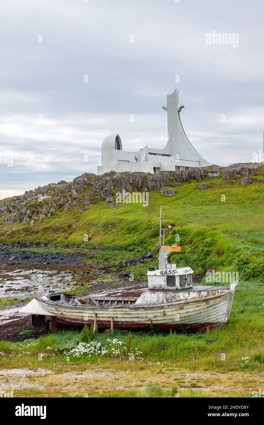 Altes Boot und neue Kirche mit auffallenden Ähnlichkeiten in Island Stockfoto