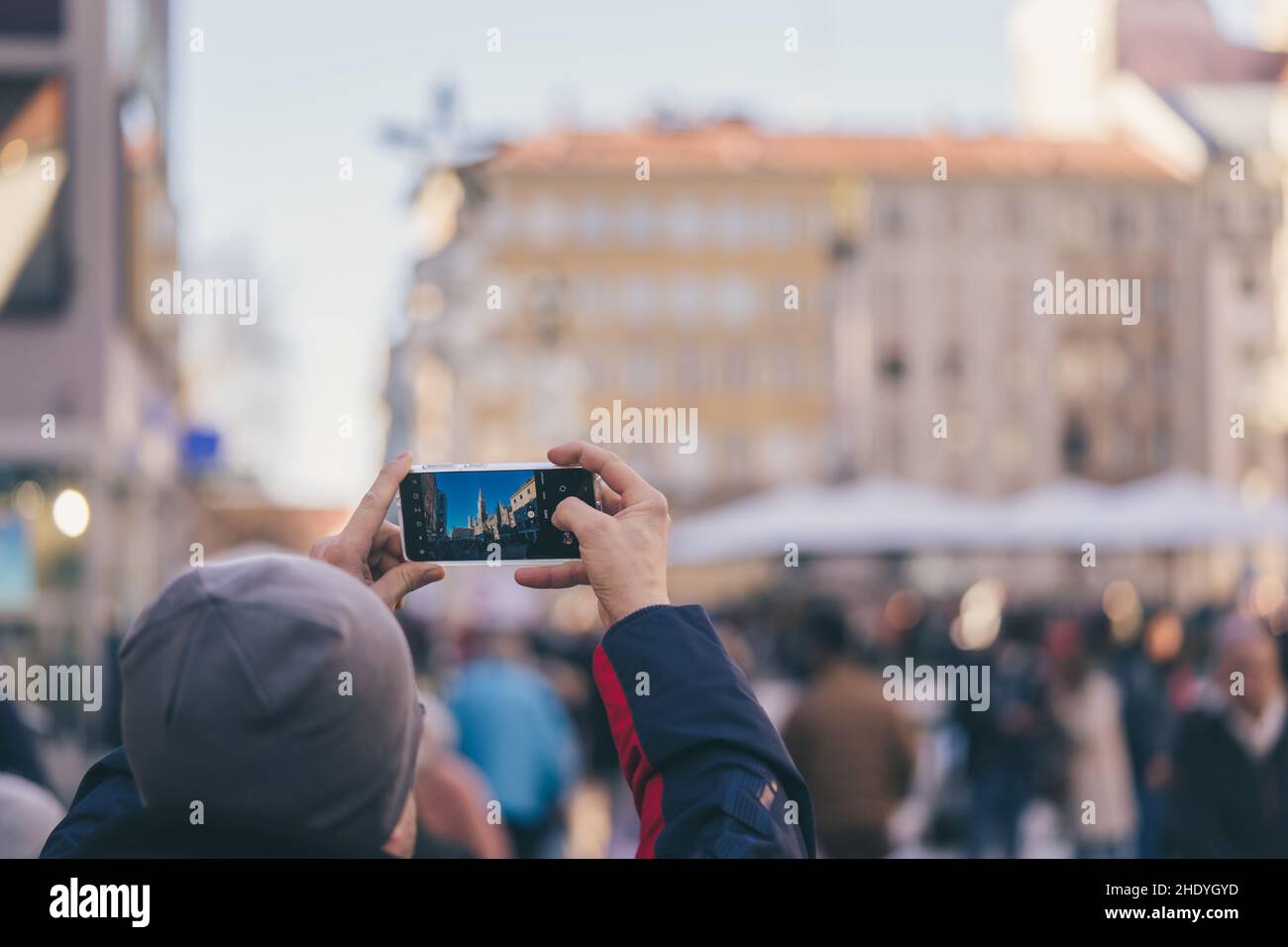 Tourist fotografiert den Münchner Marienplatz mit seinem Smartphone Stockfoto