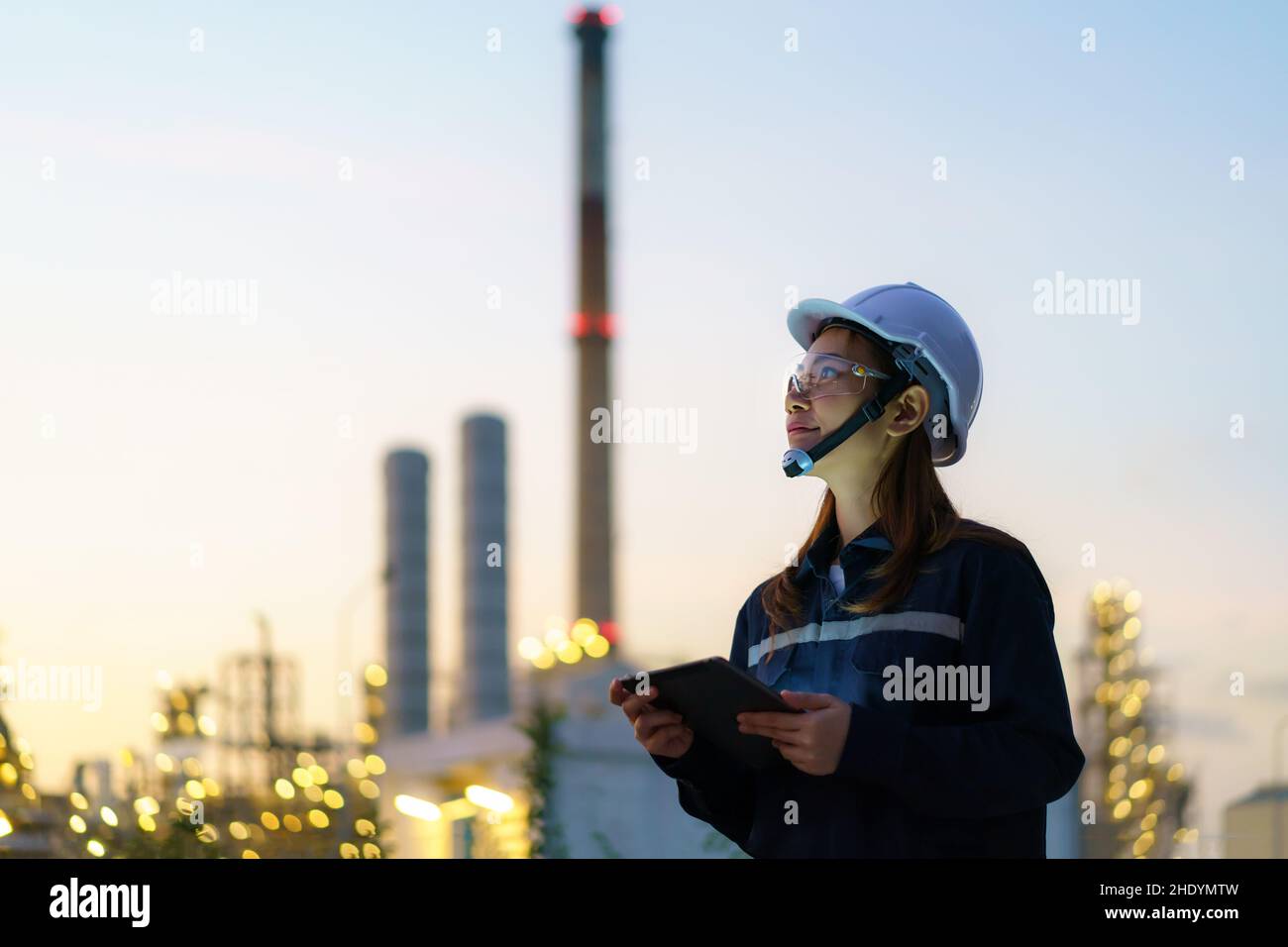 Asiatische Frau petrochemische Ingenieur arbeiten in der Nacht mit digitalen Tablette in Öl-und Gasraffinerie-Fabrik Industrie Fabrik in der Nacht für Inspektor sicher Stockfoto