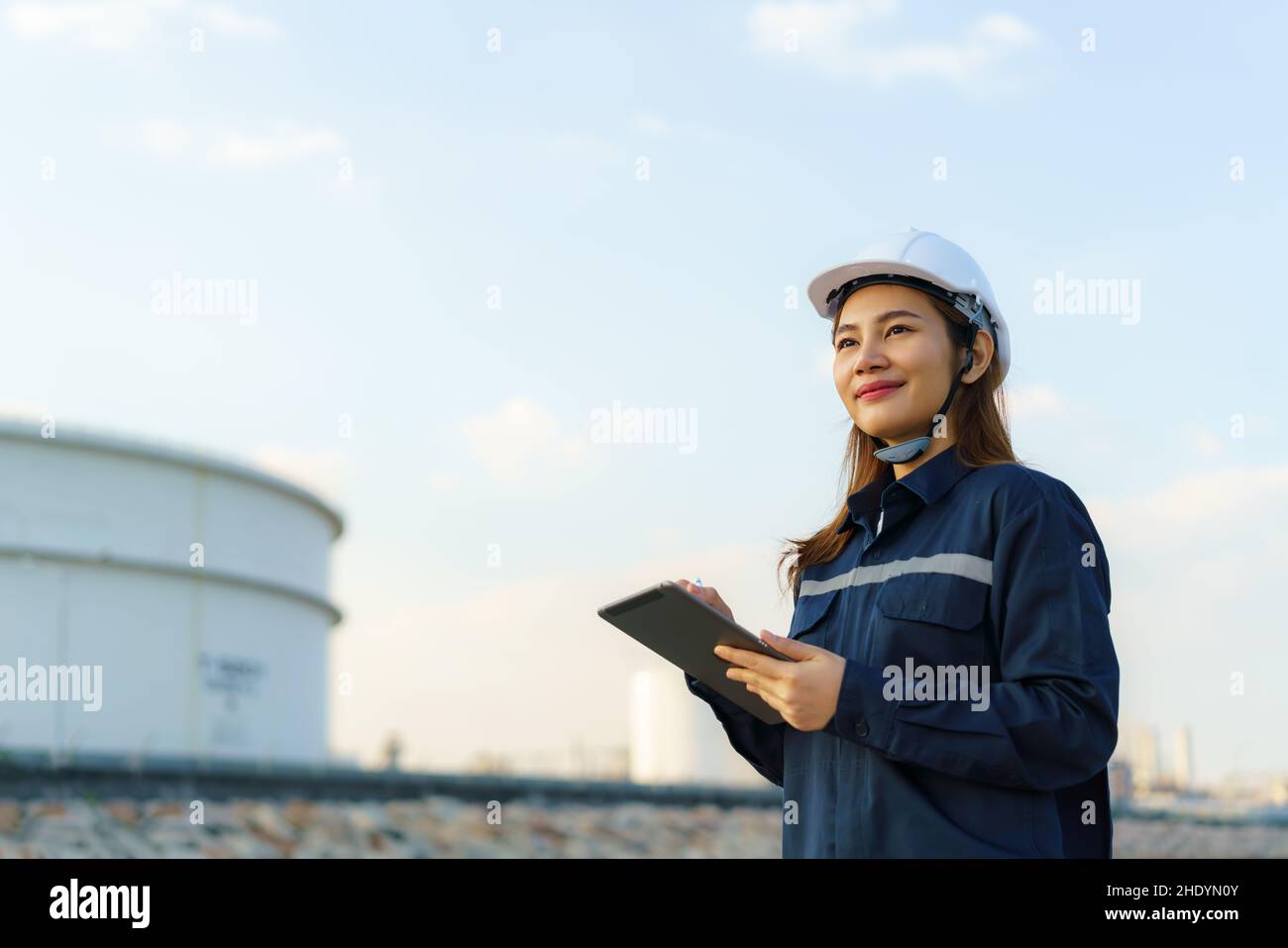 Asiatische Frau petrochemische Ingenieur arbeitet mit digitalen Tablette in Öl-und Gasraffinerie-Fabrik Industrie Fabrik in der Nacht für Inspektor Sicherheit Qualität Stockfoto