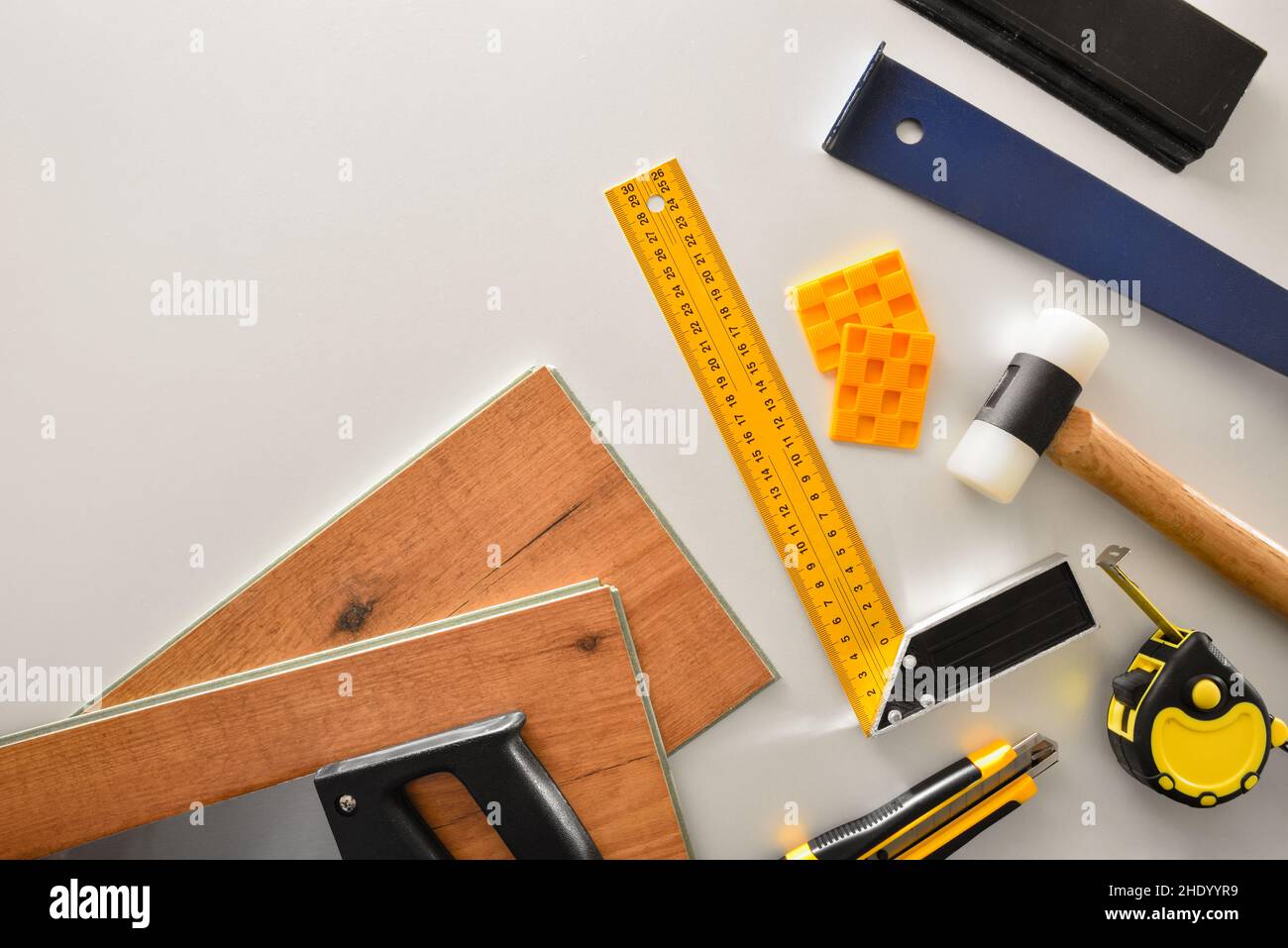 Detail der Materialien und Werkzeuge auf dem weißen Arbeitstisch eines Parkettinstallateurs. Draufsicht. Stockfoto