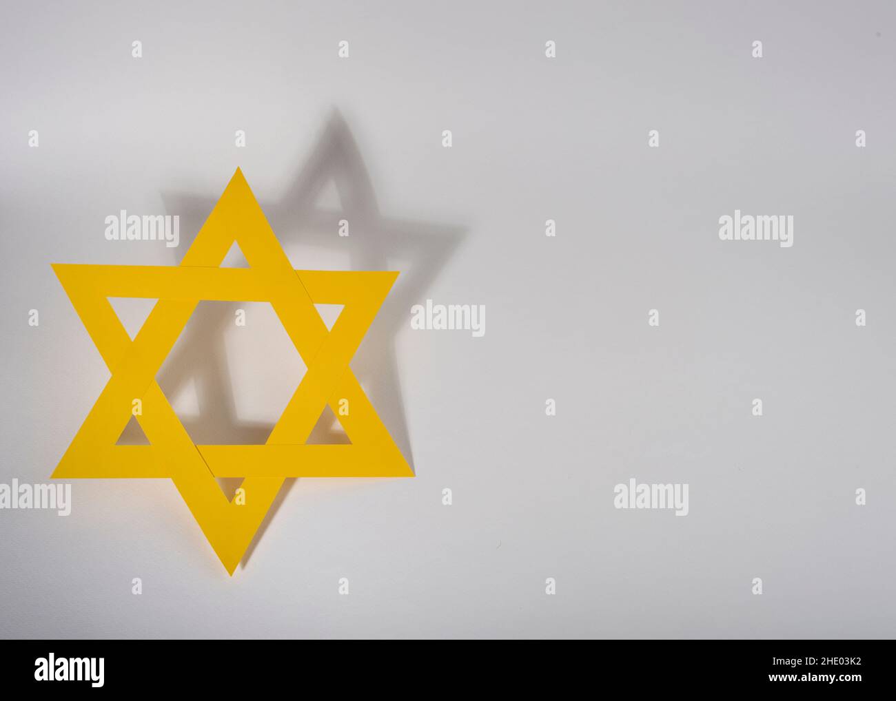 Gelber Davidstern mit Schatten auf weißem Hintergrund. Internationaler Holocaust-Gedenktag. Stockfoto
