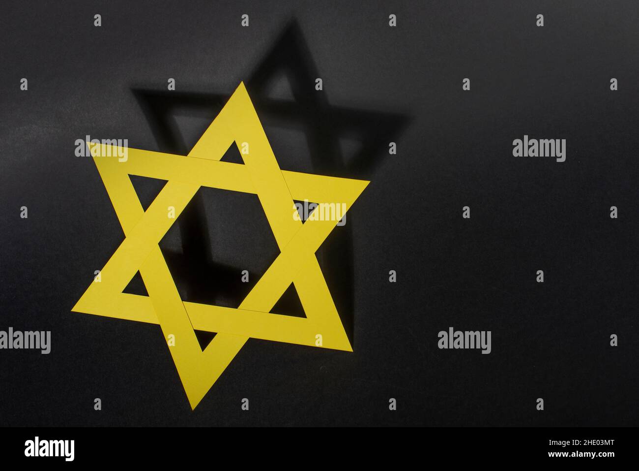 Gelber Davidstern mit Schatten auf schwarzem Hintergrund..Internationaler Holocaust-Gedenktag. Stockfoto